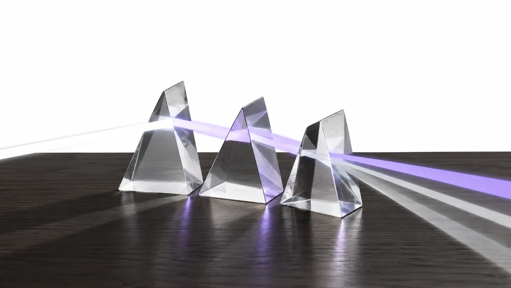 Three glass prisms splitting light, evoking three distinct settlement models