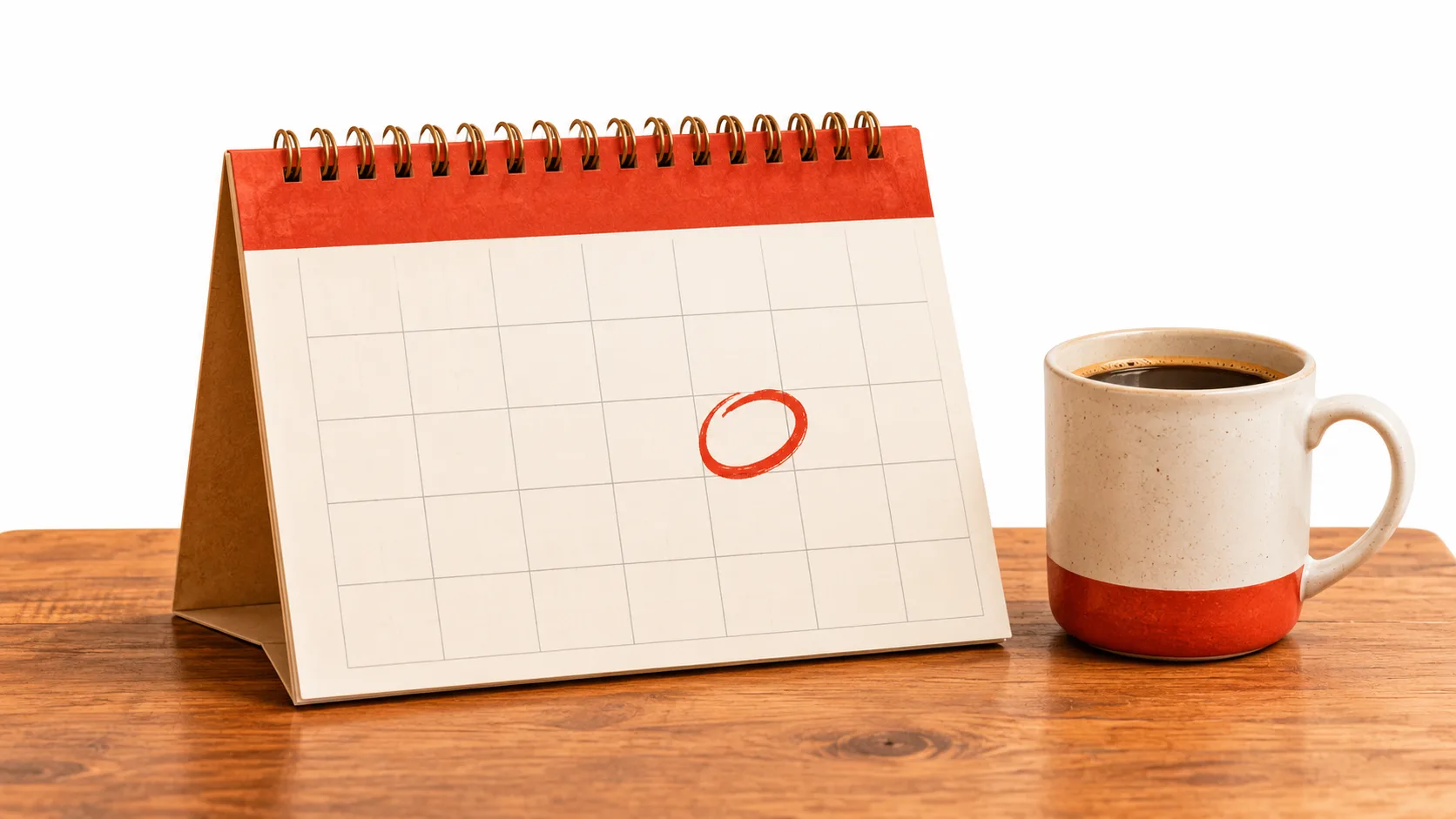 Un calendario de mesa con una fecha rodeada junto a una taza de café